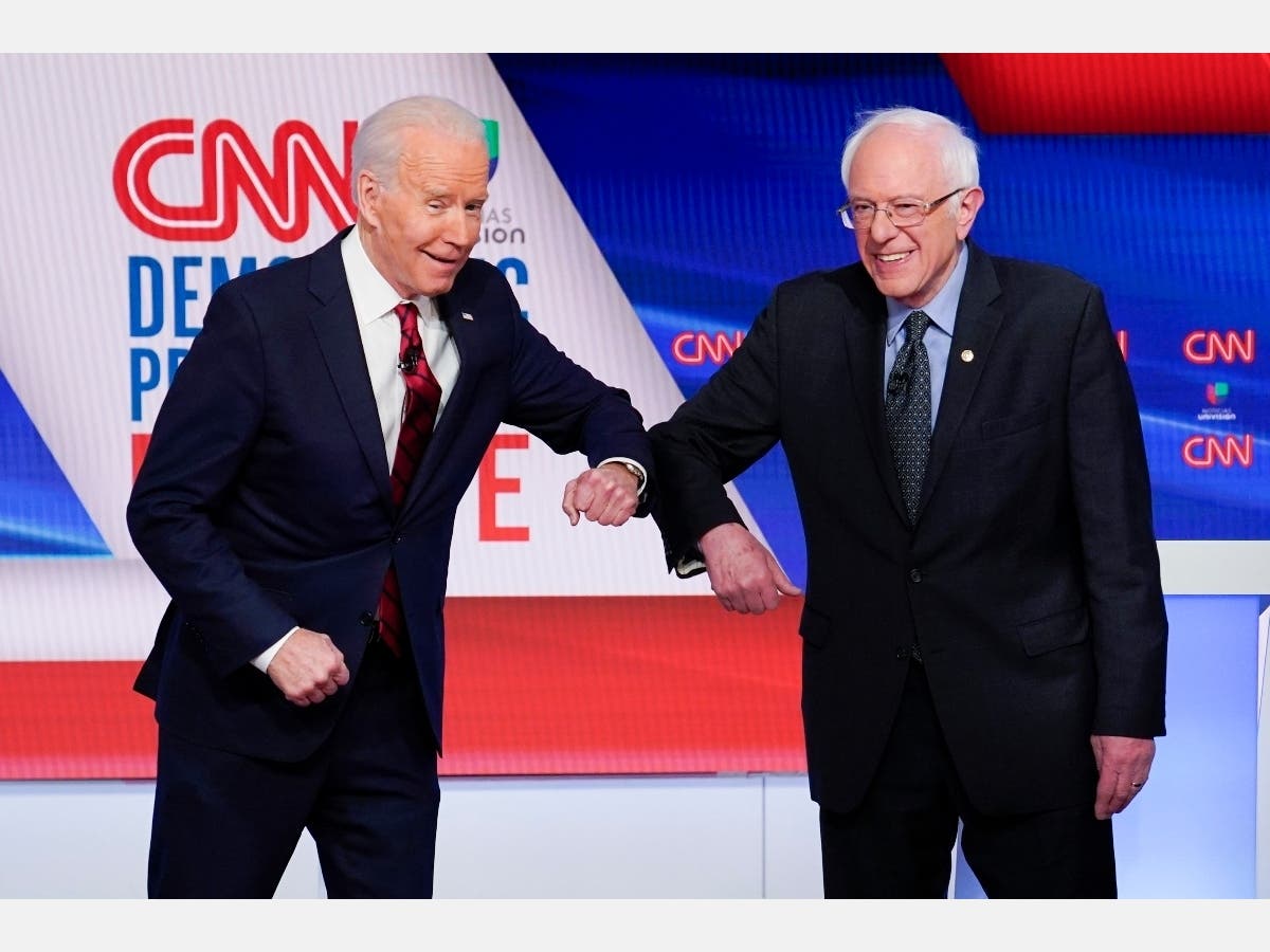 Former Vice President Joe Biden, left, and Sen. Bernie Sanders, I-Vt., right, greet each other before they participate in a Democratic presidential primary debate at CNN Studios in Washington. 