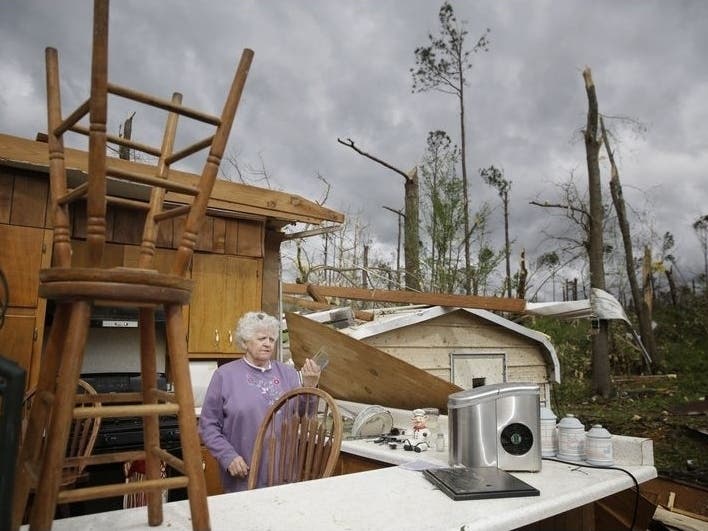 Emma Pritchett, 78, holds up a broken glass from her kitchen sink Monday, the day after a tornado hit Chatsworth, Georgia.