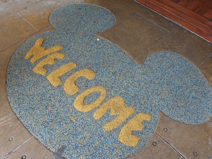 A welcome matt sits before a doorway at a Walt Disney World park. 