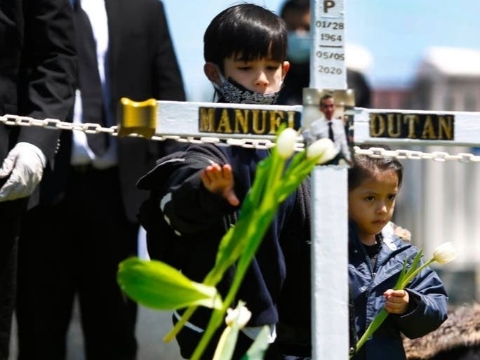The family of Manuel Dutan attends his burial. Dutan is one of 100,000 Americans who have died from the new coronavirus. 