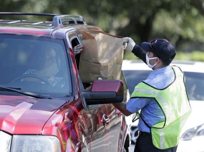 Members of Orange County Fire Rescue and volunteers pass out personal protective equipment items including disposable face masks, reusable masks and hand sanitizer to small businesses in Orlando, Fla. 