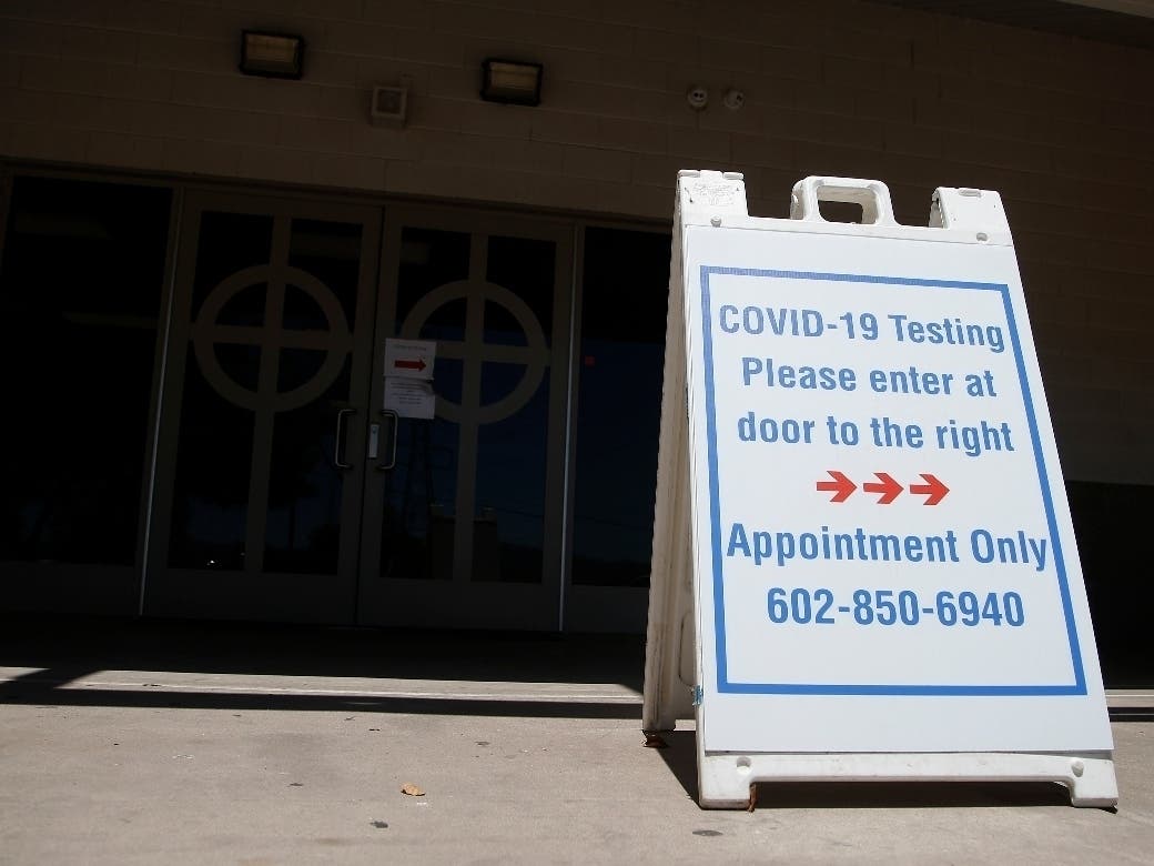 A sign points to a CVS COVID-19 testing area at St. Vincent de Paul medical clinic in Phoenix. 