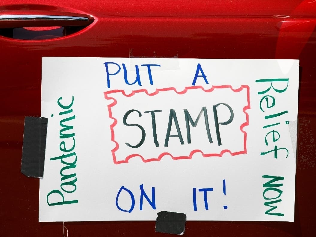 Part of a car caravan of postal employees has a sign on it asking Congress to approve emergency funding for the Postal Service.