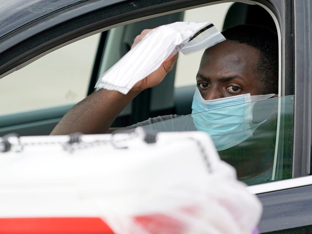 Chad Gardner returns his testing sample at a self-collection COVID-19 testing site in Houston, Texas.