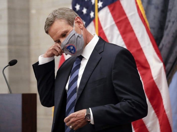 Tennessee Gov. Bill Lee removes his mask as he begins a news conference Wednesday in Nashville, Tenn. Lee is among many state leaders urging residents to do their part in containing the spread of coronavirus.