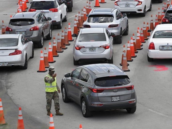 A National Guardsman directs traffic at a COVID-19 testing site outside Hard Rock Stadium in Miami Gardens, Fla. Florida is one of the nation's hot spots for coronavirus.