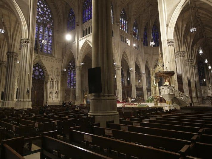 Archbishop Timothy Dolan, right, delivers his homily over mostly empty pews as he leads an Easter Mass at St. Patrick's Cathedral in New York. 