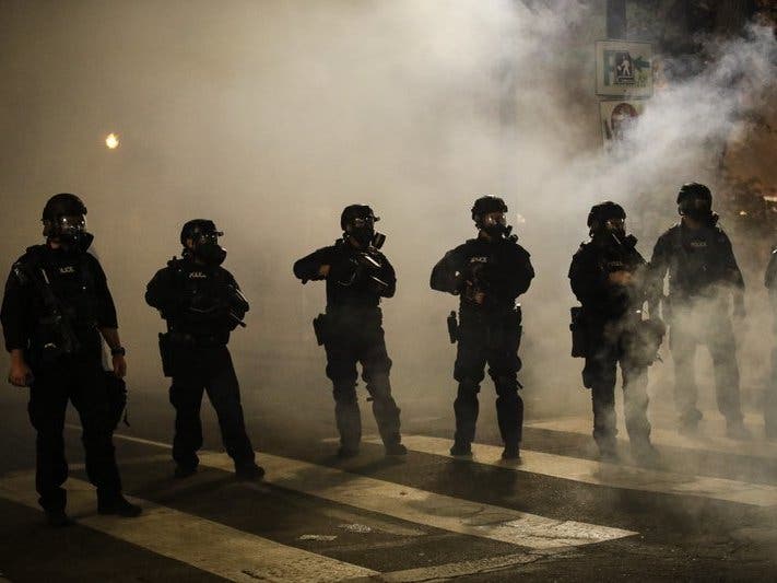 Federal officers are surrounded by smoke as they push back demonstrators during a Black Lives Matter protest at the Mark O. Hatfield United States Courthouse Wednesday, July 29, 2020, in Portland, Ore.