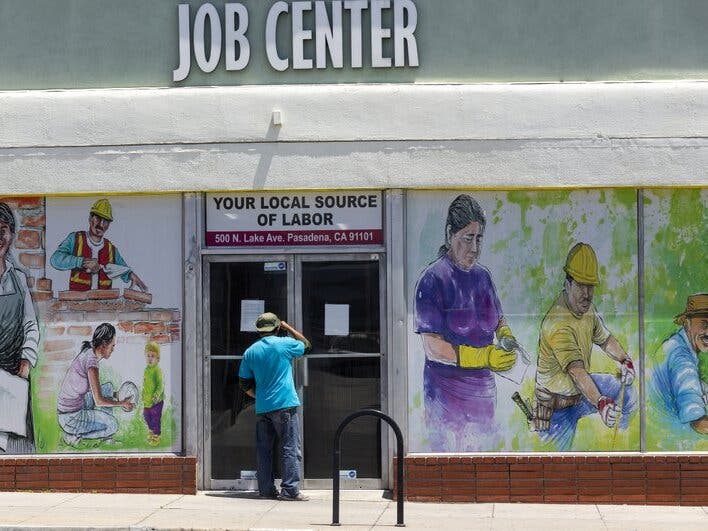 A person looks inside the closed doors of the Pasadena Community Job Center in Pasadena, Calif., during the coronavirus outbreak.