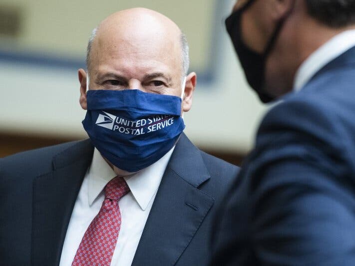 Postmaster General Louis DeJoy, left, talks with Rep. Mark Walker, R-N.C., before a House Oversight and Reform Committee hearing on the Postal Service on Capitol Hill in Washington. 