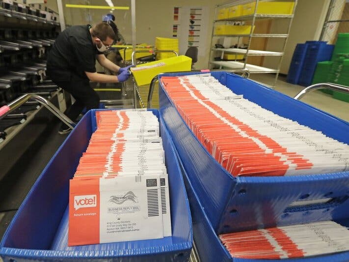 FILE - In this Aug. 5, 2020, file photo, vote-by-mail ballots are shown in sorting trays at the King County Elections headquarters in Renton, Wash.