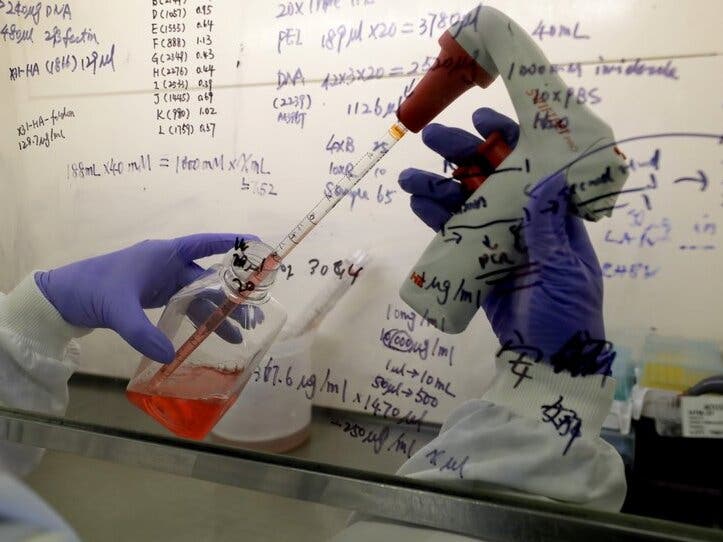 Kai Hu, a research associate transfers medium to cells, in the laboratory at Imperial College in London. 