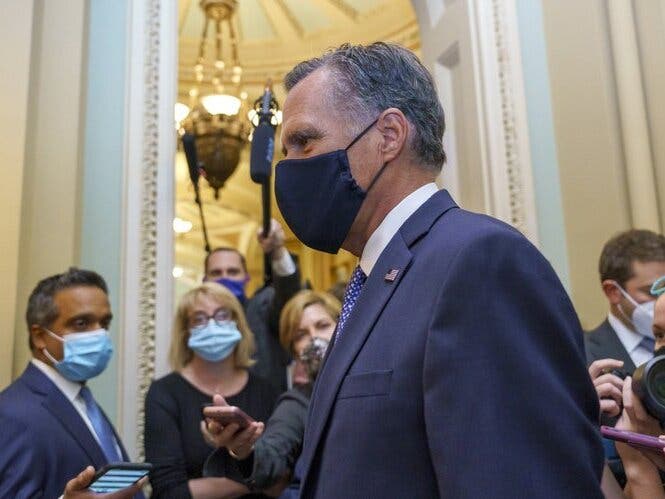 Sen. Mitt Romney, R-Utah, leaves the Senate Chamber following a vote, at the Capitol in Washington.