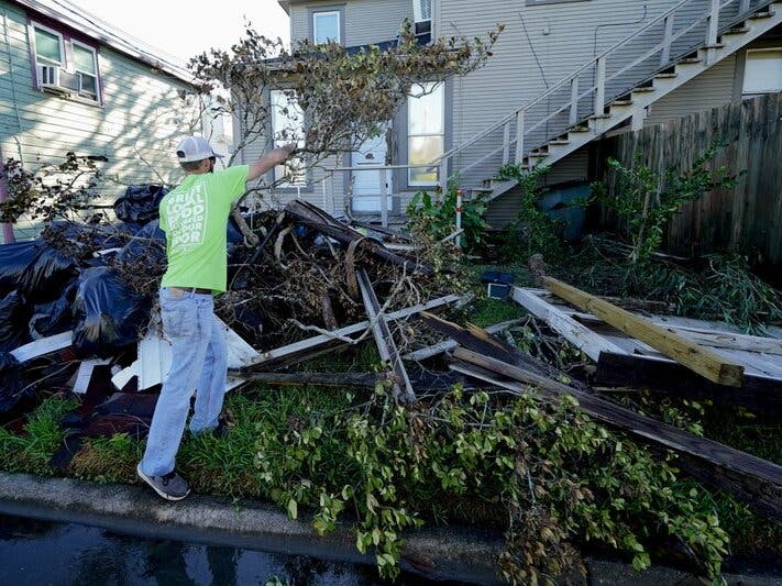 Caleb Cormier moves debris after Hurricane Delta moved through, Saturday, Oct. 10, 2020, in Lake Charles, La. Delta hit as a Category 2 hurricane with top winds of 100 mph (155 kph) before rapidly weakening over land. (AP Photo/Gerald Herbert)