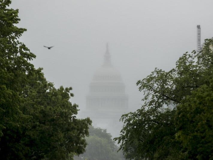 The Dome of the U.S. Capitol Building is visible through heavy fog in Washington.