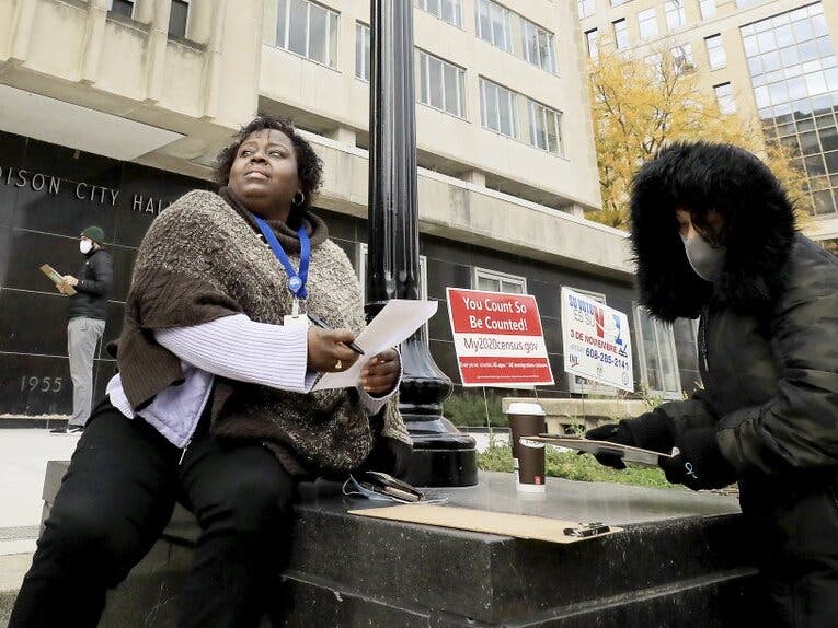 Theola Carter (left) and Carrie Braxton fill out their ballots Oct. 20 on the first day of the state's in-person absentee voting window for the Nov. 3 election outside the City-County Building In Madison, Wis. 