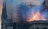 Firefighters tackle the blaze as flames and smoke rise from Notre Dame cathedral as it burns in Paris.