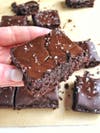 Image shows paleo brownies coated with melted chocolate and salt sprinkles.