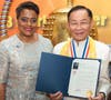 Dr. Hong, Tao-Tze, president of FOWPAL, is presented with a letter of appreciation from Mayor of the District of Columbia Muriel Bowser by Mayor Cashenna Cross of Glenarden, MD., left, for hosting bell ringing ceremonies in Washington on March 28.