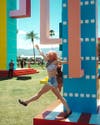 This festival goer is seen hanging off the "Colossal Cacti" created by Office Kovacs.