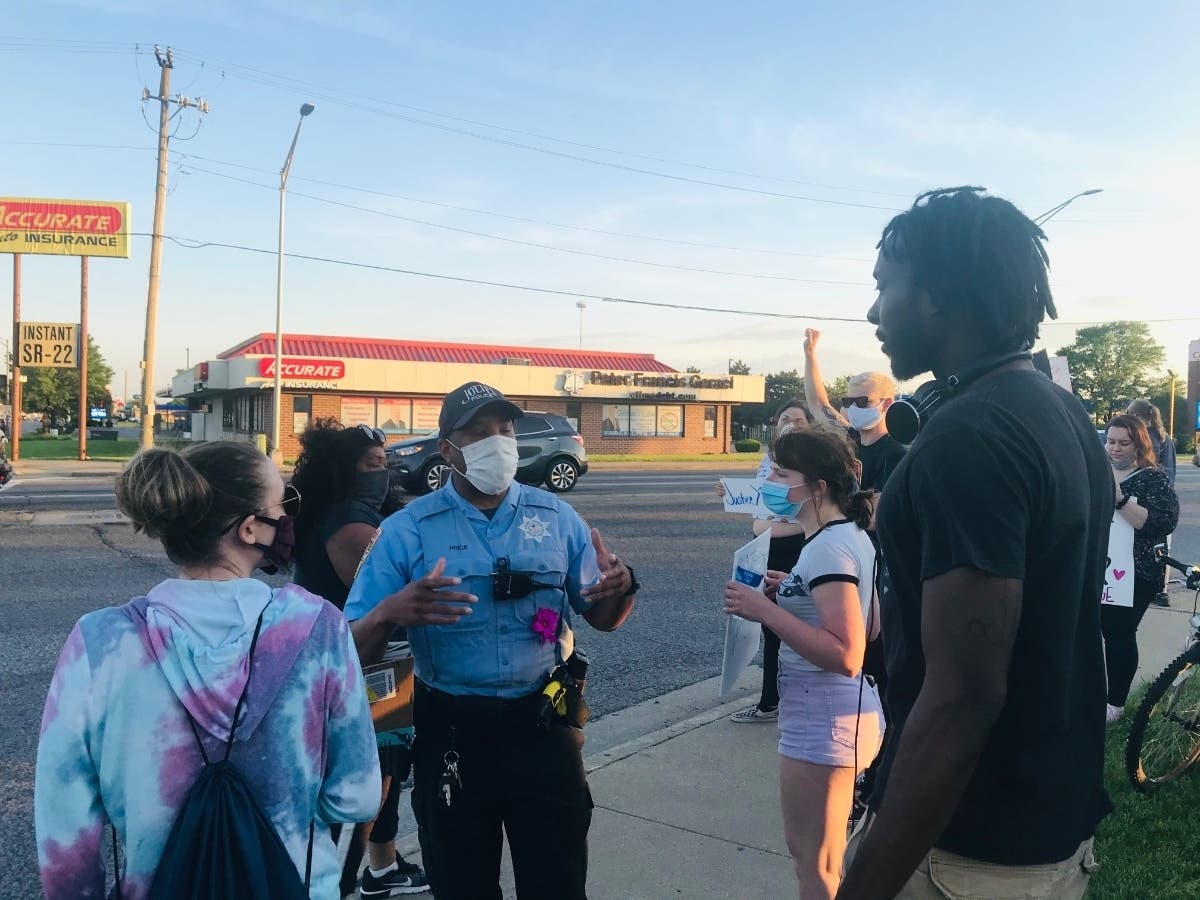 Joliet officer Jamere Price interacts with the crowd that topped out at 75 to 80 people during Monday's peaceful Black Lives Matter demonstrations at Joliet's West Jefferson Street and Larkin Avenue.