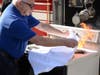 East Meadow Fire District Commissioner Carey A. Welt shows how to extinguish a stove fire using a towel as part of a Fire Prevention Week segment that aired recently on News12 LI.  