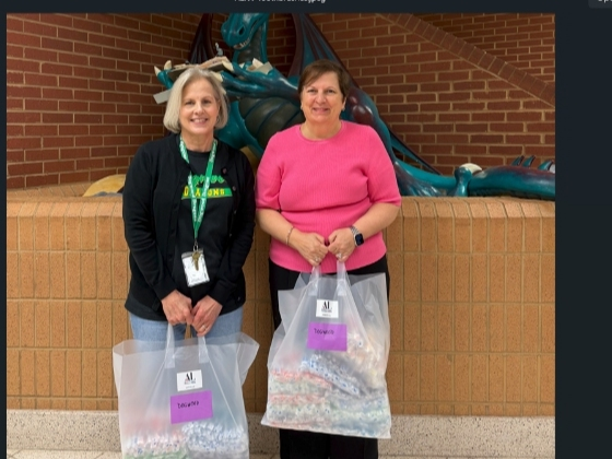 Susie Livingood (l) of Dogwood Elementary School accepts toothbrushes for students from ALNV President Gina Glen (r). 