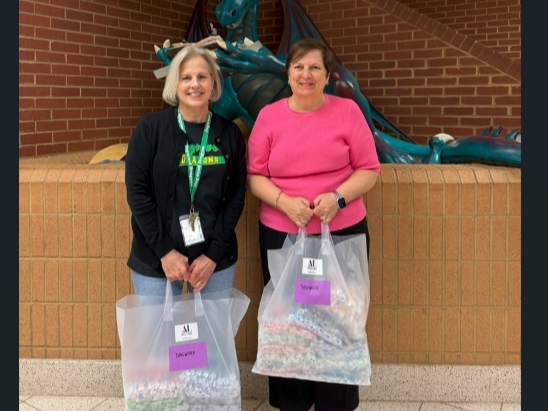 Susie Livingood (l) of Dogwood Elementary School accepts toothbrushes for students from ALNV President Gina Glenn (r)