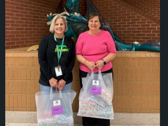Susie Livingood (l) of Dogwood Elementary School accepts toothbrushes for students from ALNV President Gina Glenn (r)