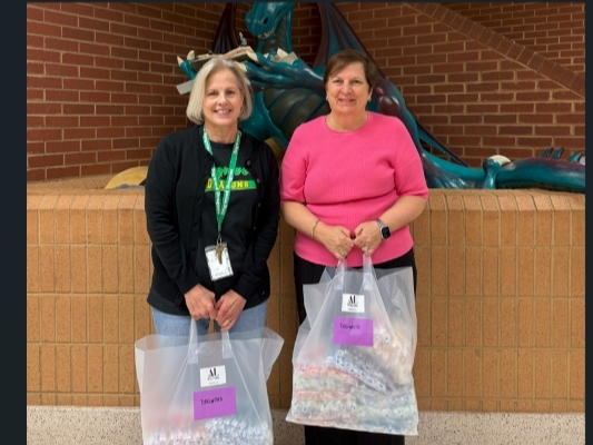 Susie Livingood (l) of Dogwood Elementary School accepts toothbrushes for students from ALNV President Gina Glenn (r)