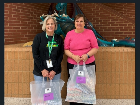 Susie Livingood (l) of Dogwood Elementary School accepts toothbrushes for students from ALNV President Gina Glenn (r)