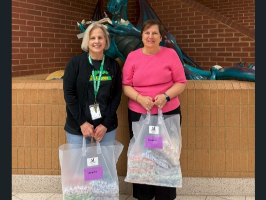 Susie Livingood (l) of Dogwood Elementary School accepts toothbrushes for students from ALNV President Gina Glenn (r)