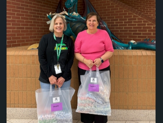 Susie Livingood (l) of Dogwood Elementary School accepts toothbrushes for students from ALNV President Gina Glenn (r)