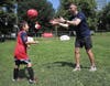 Askel and Odin Wathne of Newton warm up with goalkeeper Matt Turner of the New England Revolution before the Santander Public Clinic Series in Boston.