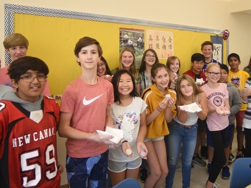 World language 7th grade students share mooncakes and Mandarin studies at Saxe Middle School. Mandarin language teacher Hsuan-Hui Smith pictured far right.