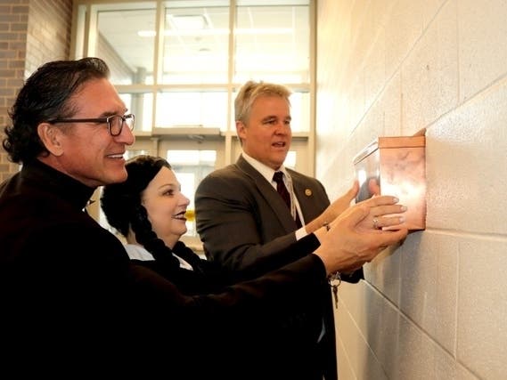 Maple Principal Dr. Nate Carter, Assistant Principal Betty Holzkopf (dressed as Wednesday from "The Adamms Family")  and Superintendent Dr. Brian Wegley place the time capsule in the wall at new Maple School on October 31.