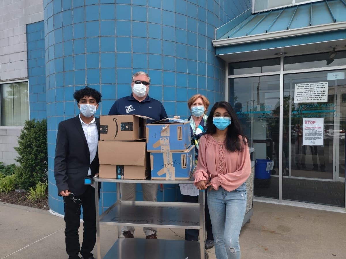 New Hyde Park Memorial High School students Parsva and Pari Shah are pictured with Principal Dr. Richard Faccio and a staff member at Mount Sinai South Nassau Hospital.