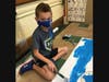 First grader Cooper Oellantoni helped paint the blue sky on the “Noun Town.”