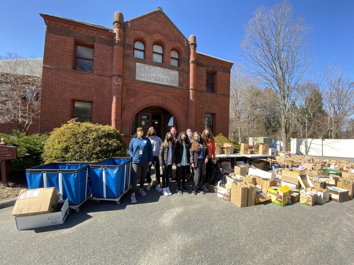 Goodnow Library staff and volunteers pose with the more than 220 donations received during a contactless, drive-up donation event.