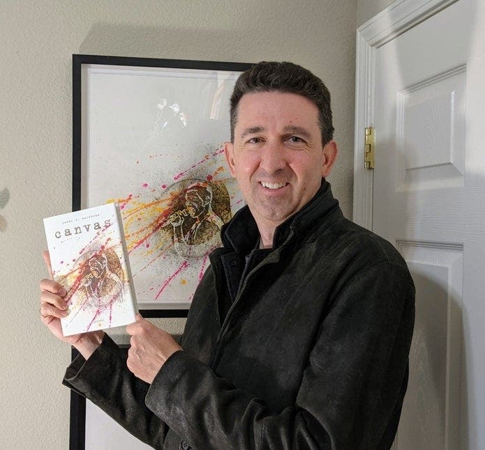 James Morehead holding his debut book “canvas”