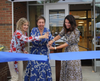 Former Board of Education President Madeline Smith, Dr. Cheryl Champ, Superintendent of Schools, and Board of Education President Jessica DeDomenico cut the ribbon in front of the new Hutchinson School.