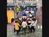 Levia Spingarn-Gabel and Michelle Rosen teach the students how to dance The Hora while holding Leah Cullinane.