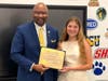 Commissioner Steven R. Mullins presents the "Commissioner Mullins Youth Leadership Award" to West Haven High School freshman Margarita Buren.