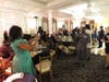 George Adzanu poses for a photo with his award, as his wife, Cynthia snaps the picture