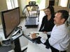 Atlantic Rehab staff demonstrate the Bionik InMotion arm.