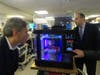 Congressman Malinowski peers into Overlook's 3-D printer as a model of an upcoming invention is being produced.