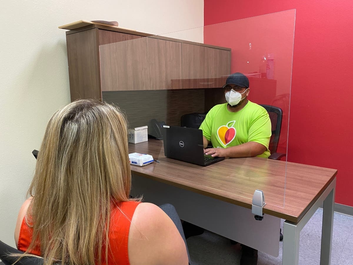 Alfredo Raya, program services representative in DeSoto County, assists a community member