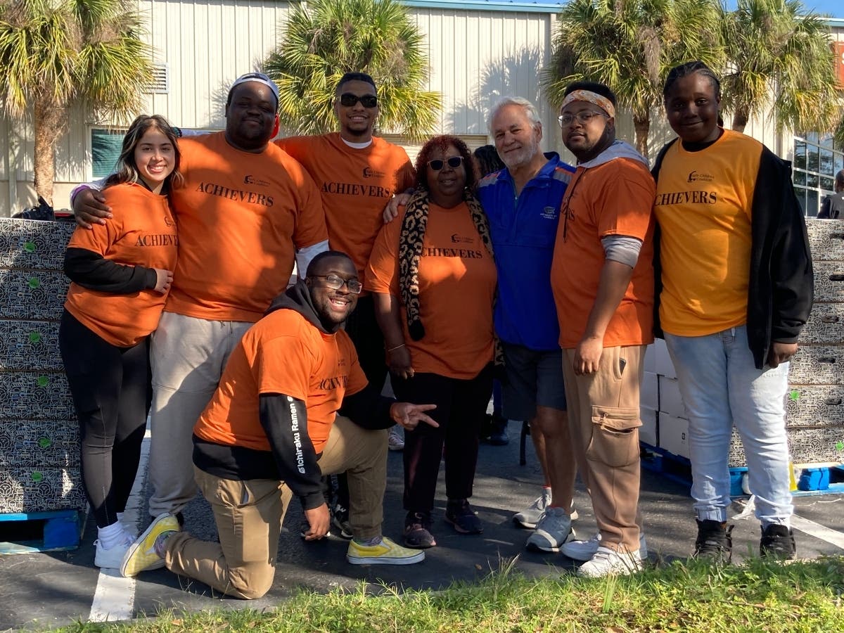 At Safe Children Coalition’s annual turkey distribution were (front) Cortnei Allen, (standing, from l-r) Madison Sosa, Jamal Watson, Jelani Mays, Achievers program manager Jone Williams, sponsor Dan Dannheisser, Josh Gilbert, and Jontavian Howard