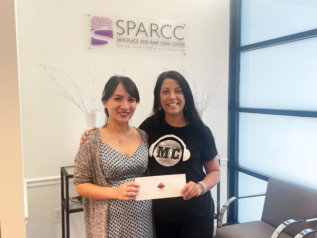 Ning Tinsley, communications manager for SPARCC (left) with Music Compound studio manager Alyssa Martin during the check presentation