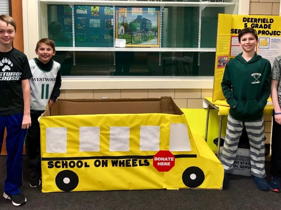 Wyatt Harvey, Will Stuehler, Von Tempel, and Greg Walsh pose with Sheila and Nora Fortune's school bus.